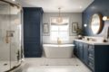 A bathroom with navy blue cabinetry and gold accents